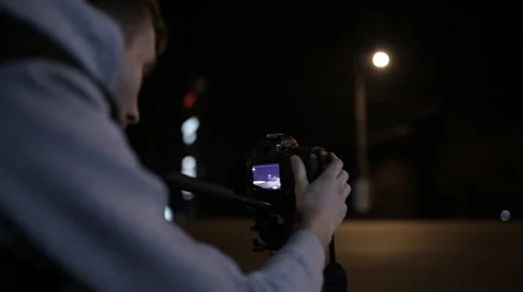 Young operator removes the camera at night road in the city center Video stock 60404480