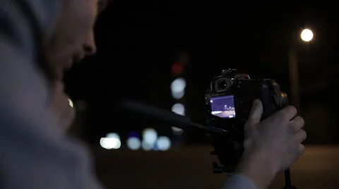 Young operator removes the camera at night road in the city center Stock Footage 60404481