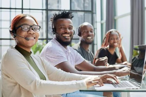 Young operators sitting at the workplace posing for the camera Stock Photos
