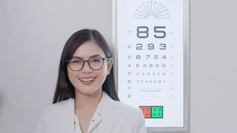 Young ophthalmologist doing visual test for customer using eye chart in optic Stock Footage 188558281