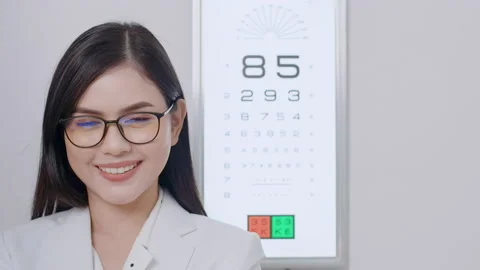 Young ophthalmologist doing visual test for customer using eye chart in optic Stock Footage 188558428
