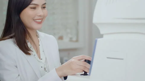 Young ophthalmologist doing a visual test for customer using autorefractor in Stock Footage 188561203