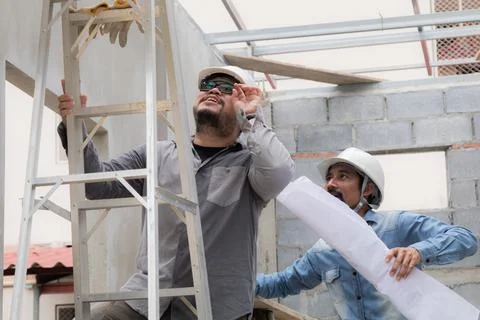 Young overweight engineering foreman climbing ladder inspect ceiling unfini.. Stock Photos