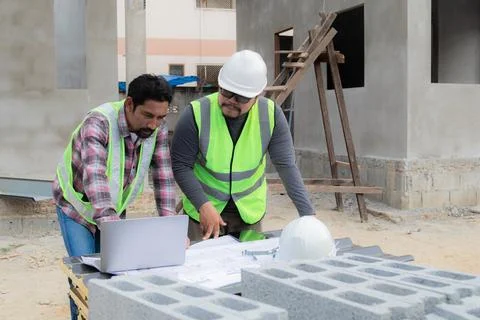 Young overweight engineering foreman reading blueprint paperwork on constru.. Stock Photos