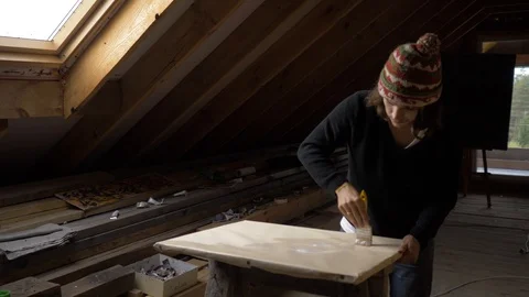 Young painter is preparing sheet on a stand, covering by layer of primer Stock Footage 96389818