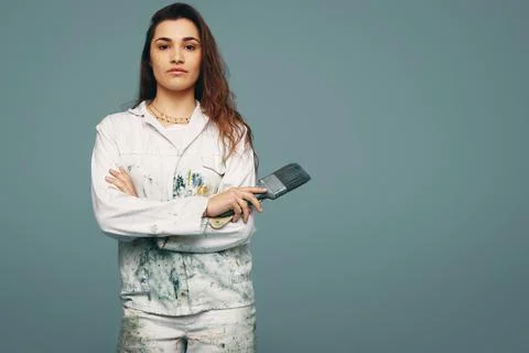 Young painter standing in a studio with paintbrushes in her hand Stock Photos