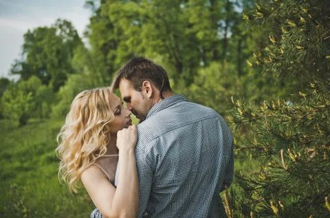 Young pair against a huge pine 3186. Stock Photos