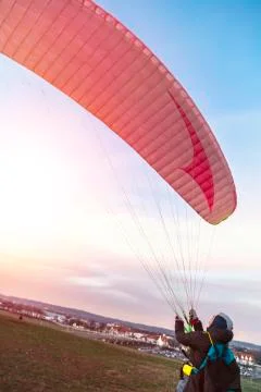 Young paraglider preparing to take off from ground 写真素材