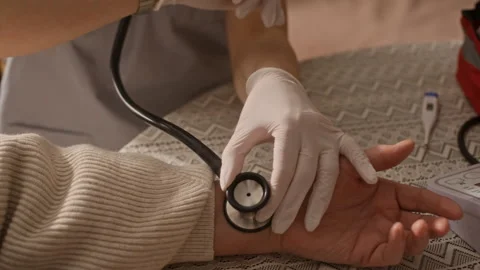 Young Paramedic Checking Pulse of Senior Woman Stock Footage 335881508