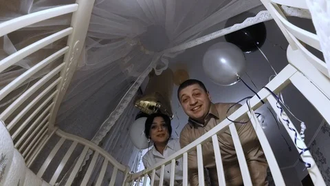 Young parents with affection looking into crib on first birthday of their baby. Stock Footage 112951703