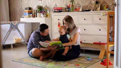 Young Parents Read the Book a Small Child in the Nursery Stock Footage 52159105