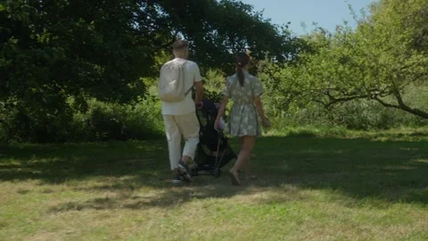 Young parents spend time together walking with their child in the park. Video stock 307861350