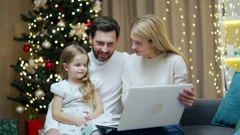 Young parents teach their child to use a laptop studying learning online browsin Stock Footage 219913879
