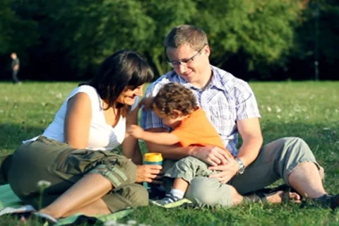 Young parents with their son sitting in the park NTSC Stock Footage 8909652