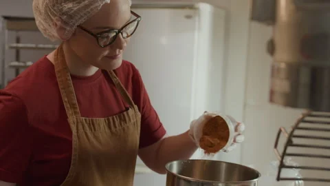 Young Pastry Chef Adding Cocoa Solids to Mixing Bowl Stock Footage 298033040