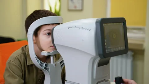 Young patient undergoing comprehensive eye examination with modern autorefractor Stock Footage 310805498