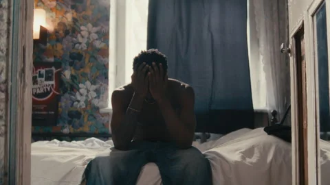 Young Pensive Black Man Getting Up from Bed and Leaving Room Vidéo 329579714