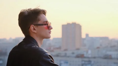 Young pensive guy on the balcony at sunset Stock-Footage 267739404