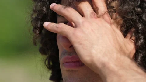 Young pensive man dazzled by the sun scrutinizes the horizon Stock Footage 220553314