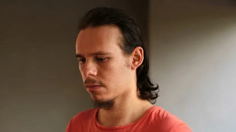 Young pensive man looking up and staring at camera Video stock 135380878