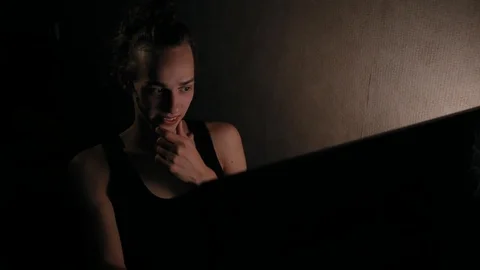 Young pensive man using computer at night in the dark room 動画素材 99051070