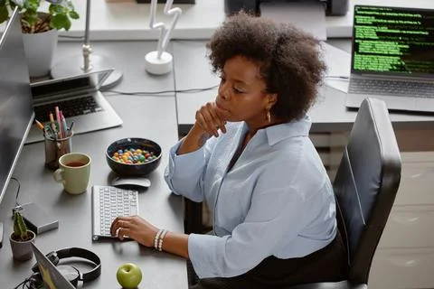 Young Pensive Software Engineer Programming on Computer Foto stock