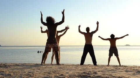 Young peope dancing at tropical beach near sea water at sunset, Thailand Stock Footage 106508057