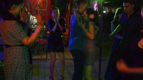 Young people are dancing around couple at dark place with color lights. Stock Footage 65451458