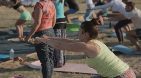 Young People Are Doing a Warm-up Before Training yoga on the shore Stock Footage 60682369