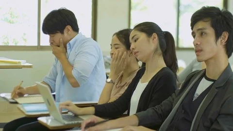 Young people are yawning and feeling sleepy in the lecture during a presentation Stock Footage