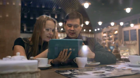 Young people in a cafe looking on the pad and talking Stock Footage 39808254
