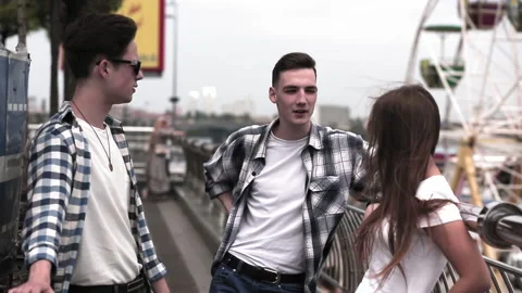 Young people chatting on the street while walking together. Friends enjoy the Stock Footage 131090780