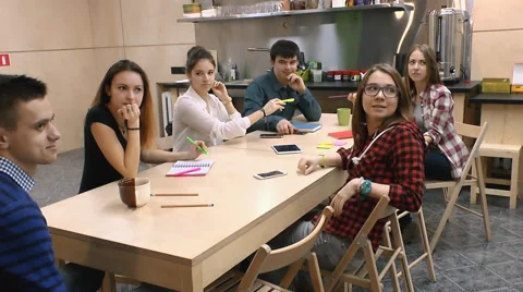 Young people communicate with each other at the table, happily and easily Stock Footage 63364621