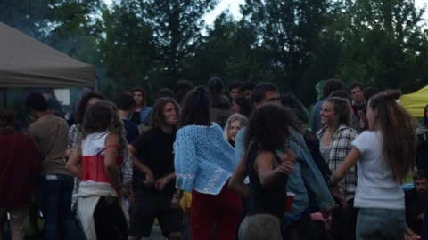 Young people dancing and jumping in an outdoor party Stock Footage 99994464