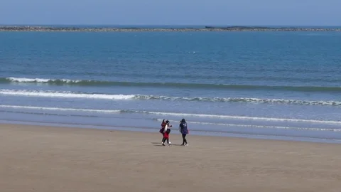 Young people on deserted beach Stock Footage 75872408