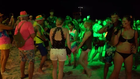 Young people from different countries dancing on the beach under the moon Stock Footage 106810896