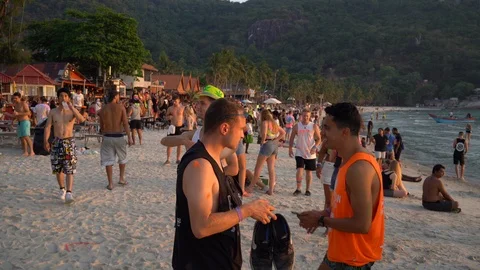 Young people from different countries meet the sunrise on Haad Rin beach Stock Footage 106969917