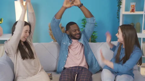Young people of different ethnicities looking at the phone at home. They rejoice Video stock 228801928