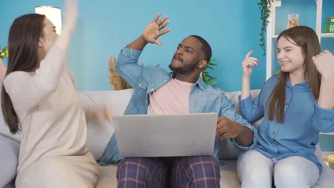 Young people of different races looking at laptop and rejoicing. Stock Footage 228803034