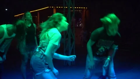 Young people energetically dancing and headbanging at a lively night event Stock Footage 319983168