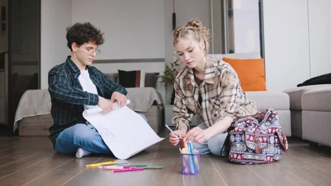 Young people engage in creative activities at home while sitting on the floor Stock Footage 346185967