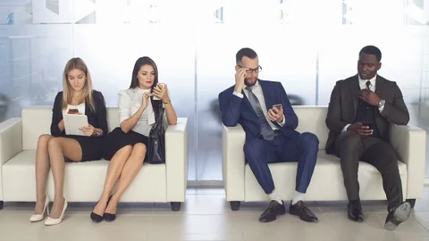 Young people expect interviews sitting on chairs in an office building. the Stock Footage 80252246