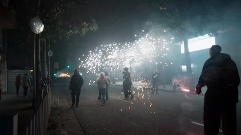 Young people following a Correfoc devil in the street  Stock Footage 100376376