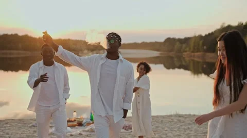 Young people having fun dancing on the lake beach at sunset Video stock 197167657