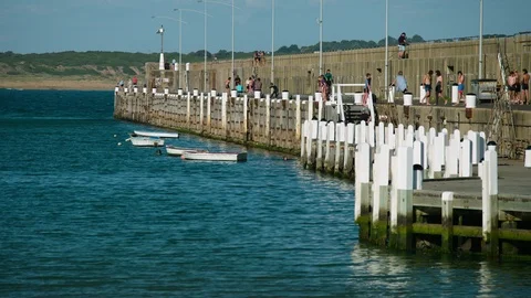 Young people jumping off the breakwater during summer. Stock Footage 87825145