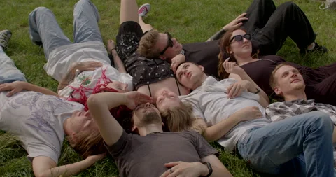 Young people lying in park. Value of physical touch human connection lifestyle Stock Footage 250410693