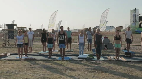 Young People Make The Workout to The Neck During exercise yoga at the seashore Stock Footage 60681810