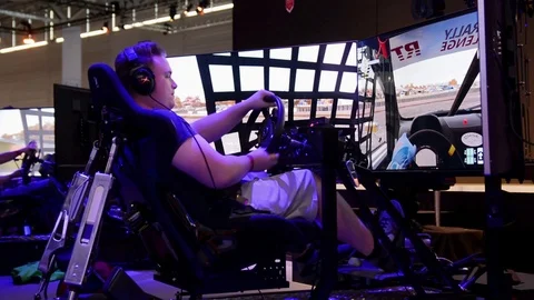 Young people playing racing game at Gamescom at Cologne Video stock 79711204