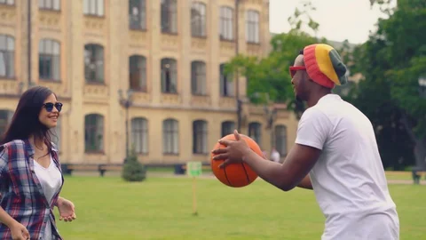 Young people playing throw each other a ball outdoors at univercity park Stock Footage 126285841