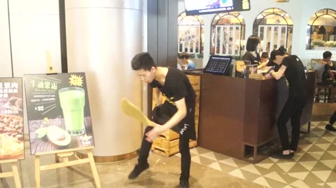 Young people practicing throwing towels in the pizza shop Stock Footage 64522348